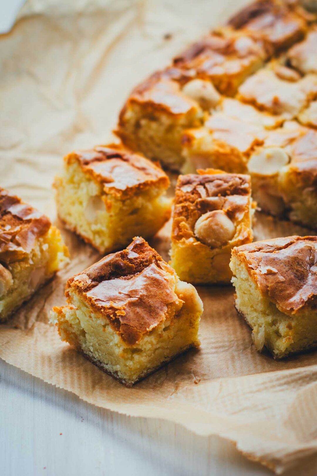 Rezept für saftige Blondies mit weißer Schokolade und gesalzenen Macadamias. Das sind quasi goldbraune Brownies ohne dunkle Schokolade, mit karamelligem Geschmack. Schnell gemacht aus nur wenigen Zutaten. Ein echtes Standardrezept! | moeyskitchen.com