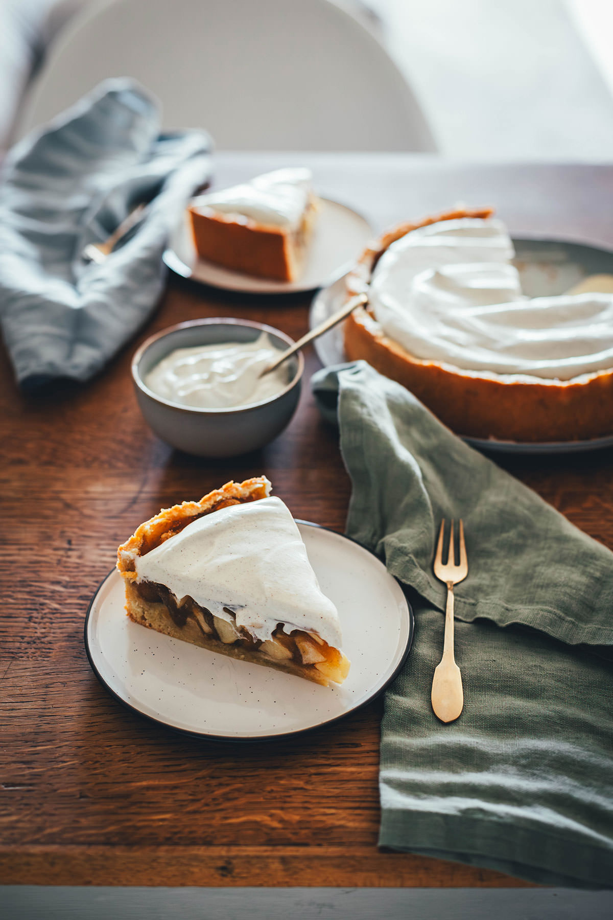 Rezept für Apfelkuchen mit knusprigem Mürbeteigboden und einer Füllung mit Äpfeln. Vanillepuddingpulver wird hier einfach mit Apfelsaft angerührt und mit Apfelstückchen gefüllt. Das ergibt die köstliche Füllung für diesen simplen Apfel-Pudding-Kuchen. Getoppt wird der Kuchen dann mit einer ganz lockeren Schmandcreme mit Vanille. | moeyskitchen.com