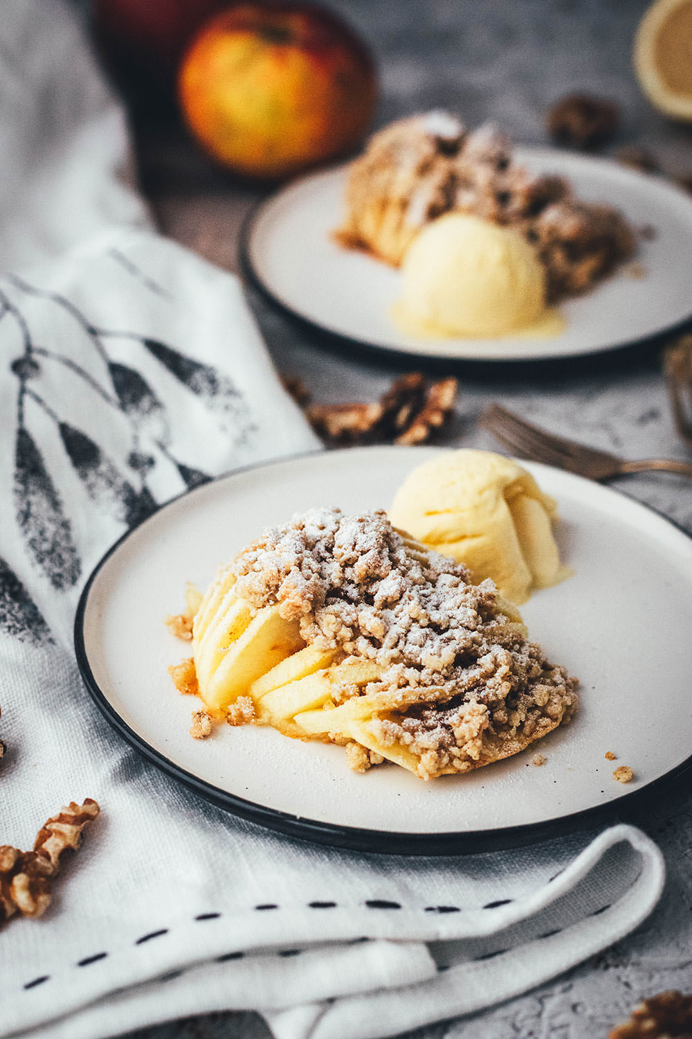 Wunderbare Rezeptidee für gebackene Äpfel mit Streuseln. Süßer Bratapfel trifft auf klassischen Apple Crumble oder Apple Crisp – heraus kommt mein Hasselback Bratapfel. Dafür werden halbierte Äpfel fächerförmig eingeschnitten, im Ofen gebacken und dann mit leckeren Streuseln bestreut. In diesen stecken gehackte Walnüsse und Haferflocken, das macht sie lecker und knusprig! | moeyskitchen.com